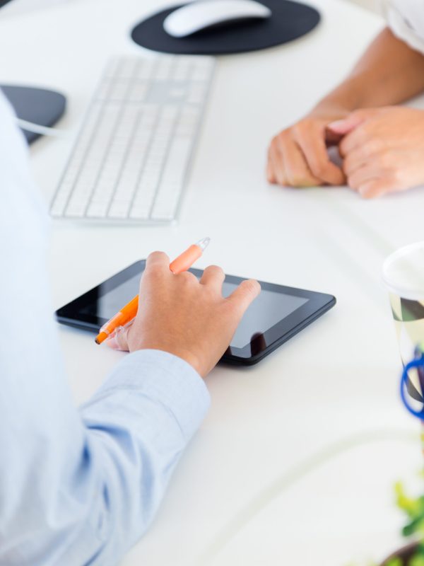 Portrait of two business woman working in office with digital tablet.